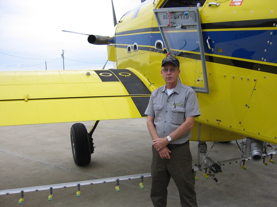 Missouri pilot Mike Lee stands next to a crop-duster. "I know some people who have had accidents. I've had friends that got killed in these things," he says.