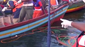 Rescue workers are seen on Friday at the scene where a ferry overturned in Lake Victoria, Tanzania.