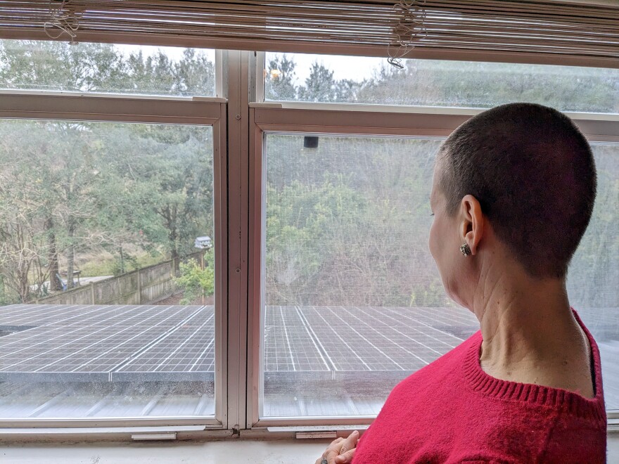 Lea Campbell looks at her solar panels from an upstairs room in her Ocean Springs, Mississippi home, December 17, 2022.