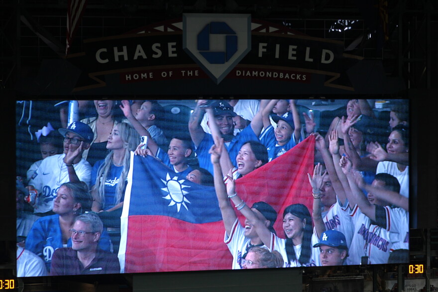 A Chase Field big screen shows fans in Diamondbacks jerseys holding up a Taiwanese flag.
