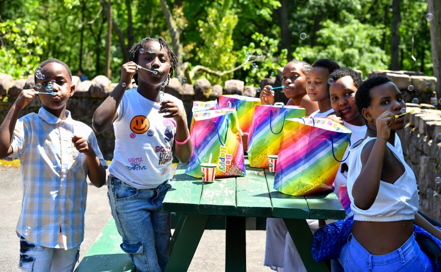  Cousins, all from Africa, Moses Muisgha, 6, Akeza Providence, 8, Clarissa Unease, 13, Isimbi Keza Jesca, 8, Alliance Uwase, 17, and Gloria Uwajeneza, 13, play
with bubbles at the Refugee Day event. 