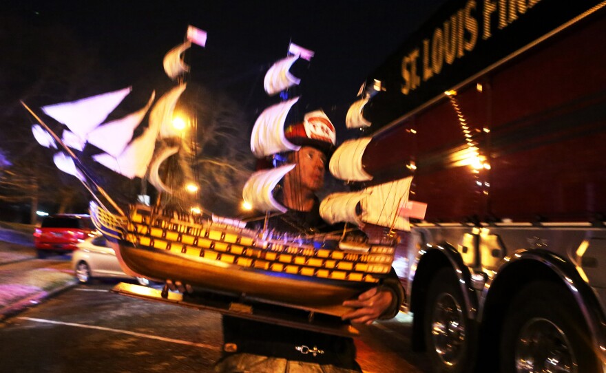 A firefighter carries a ship replica to a firetruck on Tuesday, following a fire at the Karpeles Manuscript Library Museum in St. Louis. Officials with the museum say there was little to no loss and minimal water damage to items in the building.