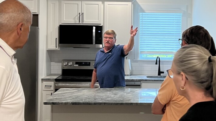 Norman Clarke, a retired Harwich fire chief, gives a public tour of the newly repurposed Old Bank Street Firehouse on July 16, 2026. The former firehouse now has three affordable apartments on the second floor. The renovation of the building to meet modern needs is featured in the Boston Society of Architects' first regional guidebook on adaptive reuse.