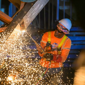 Pictured: A worker with DPW contractor, Rumina Construction, cuts through the steel framework of the former Addelita Cancryn Pedestrian Bridge on St. Thomas during demolition work Friday evening.