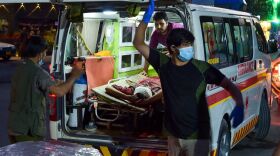 Medical staff load an injured man into an ambulance after two powerful explosions, which killed at least six people, outside the airport in Kabul, Afghanistan, on Thursday.