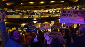 People cheer during a performance by Tom Morello at a campaign event for a proposed "billionaires tax," in Los Angeles, Wednesday, Feb. 18, 2026.