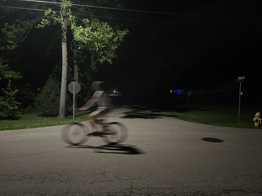 A cyclist rides at night through Yellow Springs