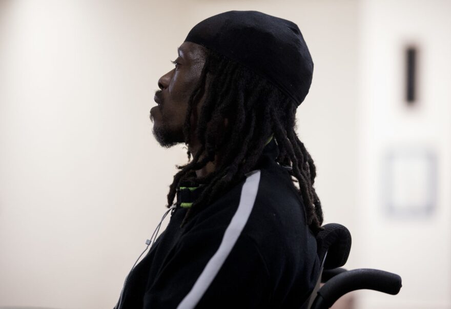 Kwame Dew, a single father of three, sits in his electric wheelchair during a meeting of the Urban Re-Entry Group.  