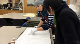 Online editor Isolde Raftery reads an old residential ledger at the Puget Sound Regional Branch of the Washington State Archives in Bellevue.