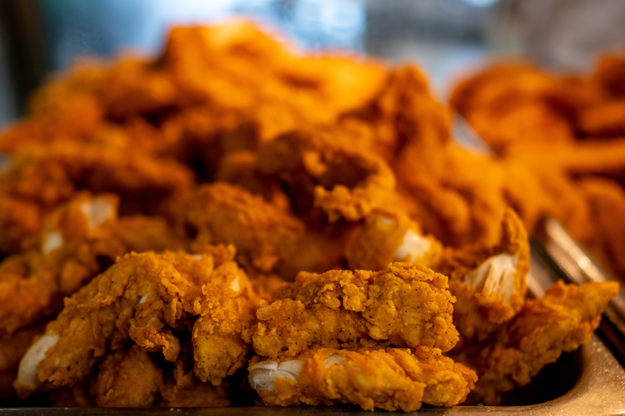 A close-up of a pile of flaky, breaded chicken strips. 