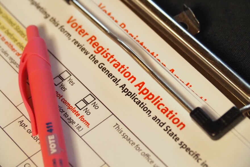 A stack of clipboards with blank voter registration application forms sits on a volunteer table after a naturalization ceremony at the federal courthouse in downtown Indianapolis on Thursday, July 3, 2025.