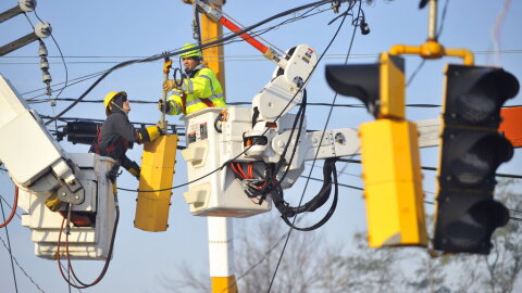 Workers from the Connecticut Department of Transportation and Connecticut Light & Power work on downed power lines on Route 5 in South Windsor, Conn., Monday, Oct. 31, 2011.