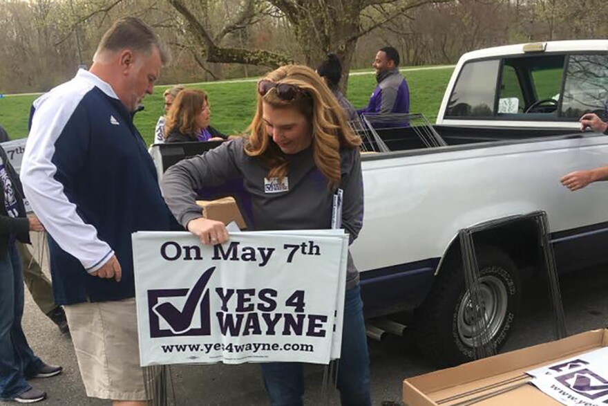 Volunteers distribute signs for Wayne Township Schools ahead of the May 2019 election.