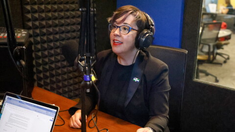Mayor Barbara Buffaloe sits in a recording booth. She's wearing headphones and a dark blazer. She's speaking into a microphone.