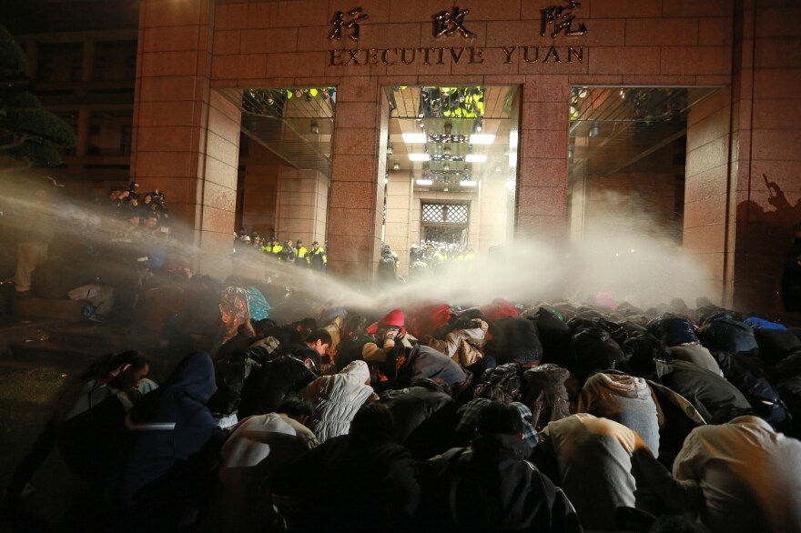 Police spray protesters with a water cannon during a demonstration outside the Executive Yuan in Taipei early Monday, following Taiwan President Ma Ying-jeou's refusal to scrap a contentious trade agreement with China.