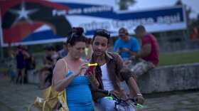 In this Aug. 31, 2016 photo, a woman connects to wifi in Revolution Square in Santa Clara, Cuba. 