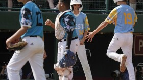 El Segundo, Calif.'s Louis Lappe (19) and celebrate after scoring on a double by Lucas Keldorf off Curacao's Sean Serverie (12) during the first inning of the Little League World Series Championship game in South Williamsport, Pa., Sunday, Aug. 27, 2023. (AP Photo/Gene J. Puskar)