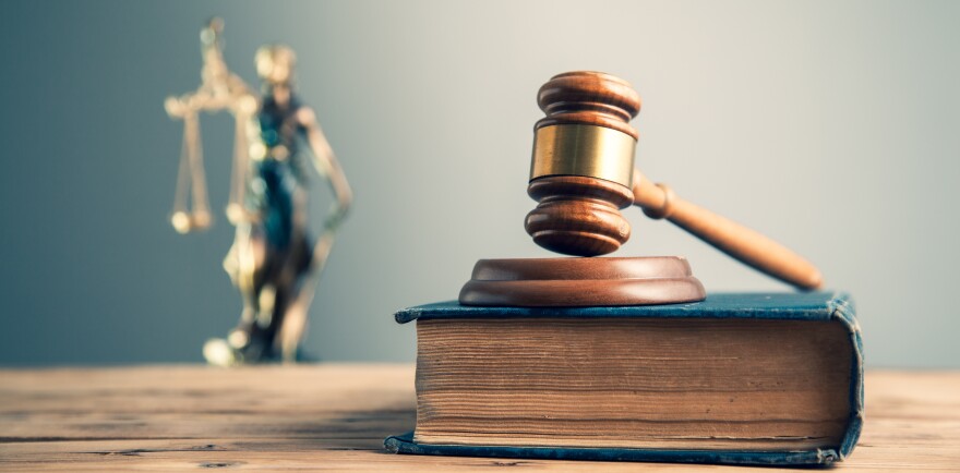 wooden judge on book with justice lady on desk