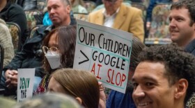 people siting and holding signs against a Google data center