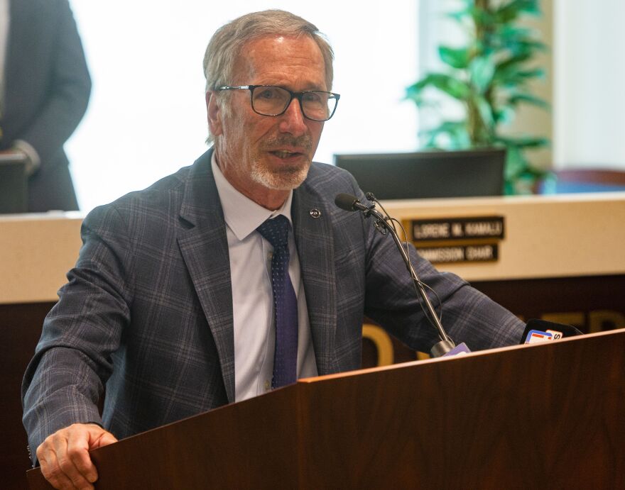  Weber County Commissioner Gage Froerer talks while standing behind a brown podium and microphone.