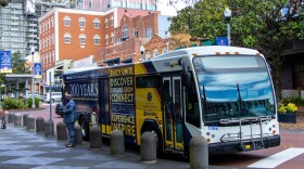  A StarMetro bus is parked in downtown Tallahassee featuring an ad for the city's bicentennial
