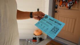 Milliken resident Derek Lucero holds up a blue flyer announcing the app that was created for him to monitor his water usage on his new smart meter. It says in part, "Town Of Milliken Smart Meters. Good news! Your home now has a smart water meter!"