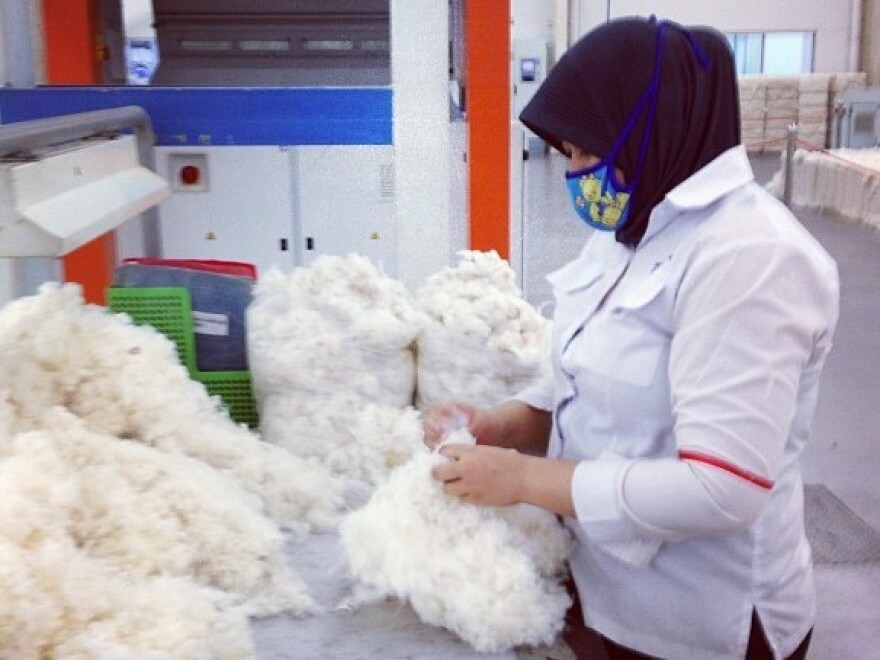 Other than this woman spot-checking some of the cotton, no human hands touch the yarn. It's all machines, shooting strings of cotton, twisting and twirling and winding.
