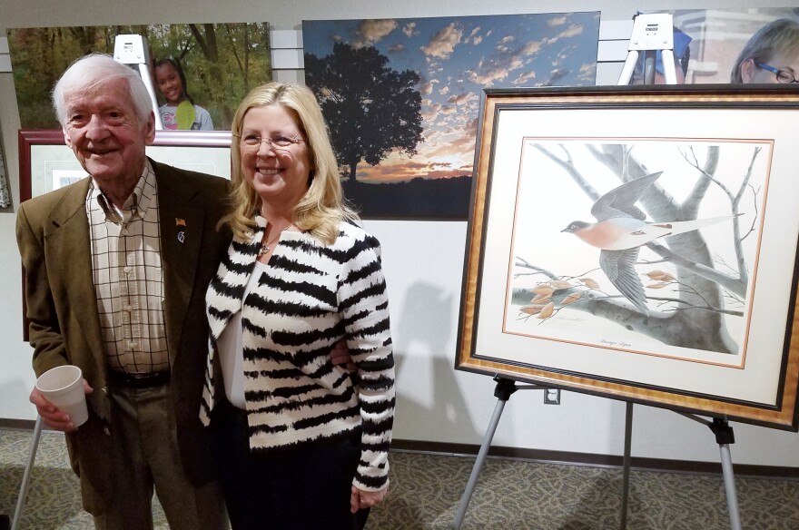 Artist John Ruthven and Great Parks Chief Operating Officer Rebecca McDonough pose for a picture beside his painting of "Martha," the famous last passenger pigeon. 