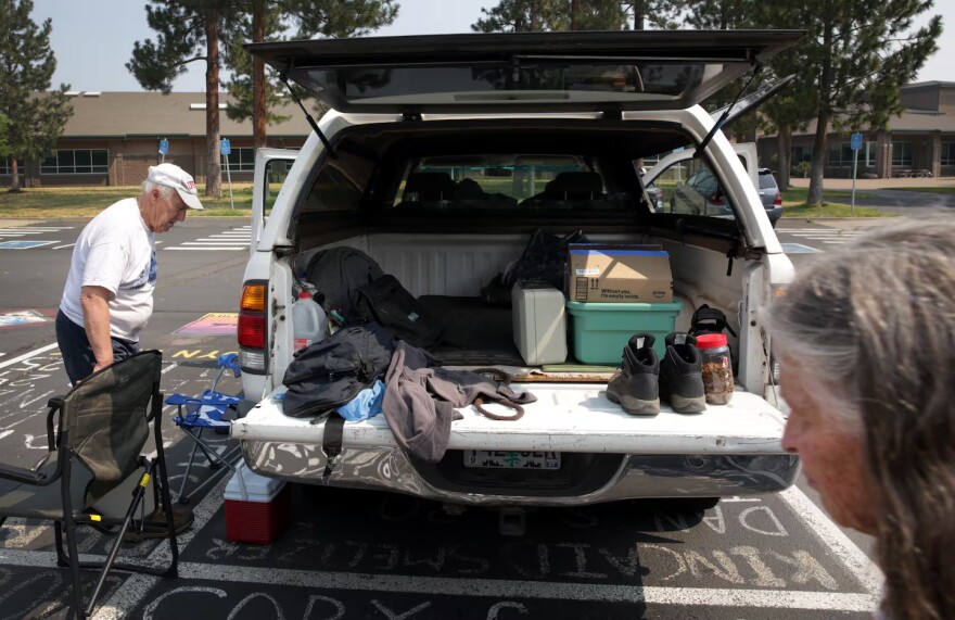 Tim Draxler, left, and his wife Barbara organize their belongings after a night at a Red Cross shelter in Sisters, Ore., July 23, 2026. The couple were evacuated from their home outside of Sisters under Level 3 “Go Now” orders on Wednesday evening as the Adawa Butte Fire burns through the area.
