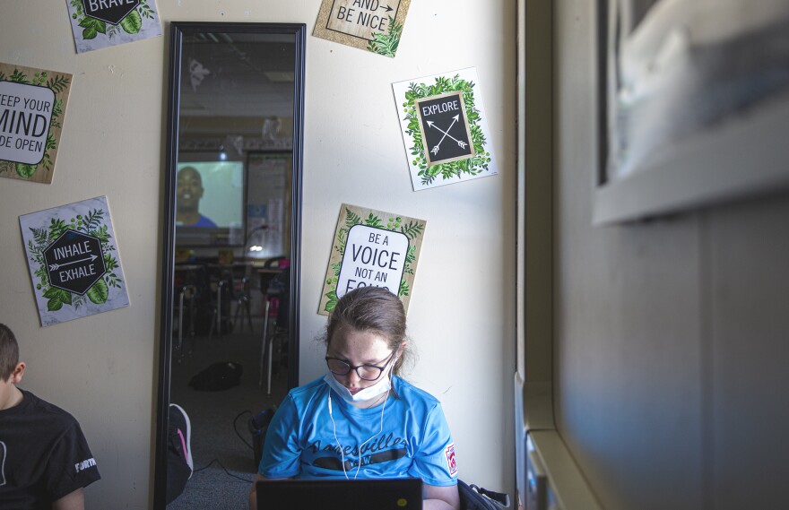 Moshannon Valley Elementary School student Lucy Fox is doing school work near a classroom corner that features positive messages printed on the wall.