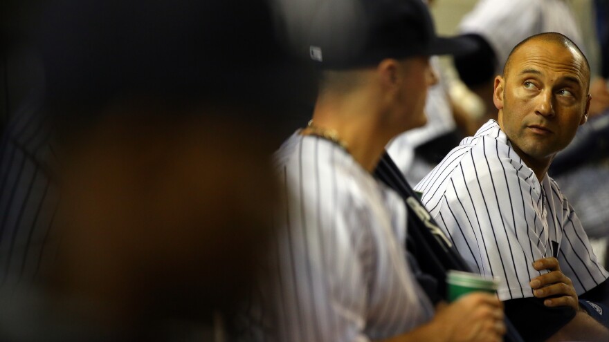 Jeter looks on from the Yankees dugout in his last game at Yankee Stadium.