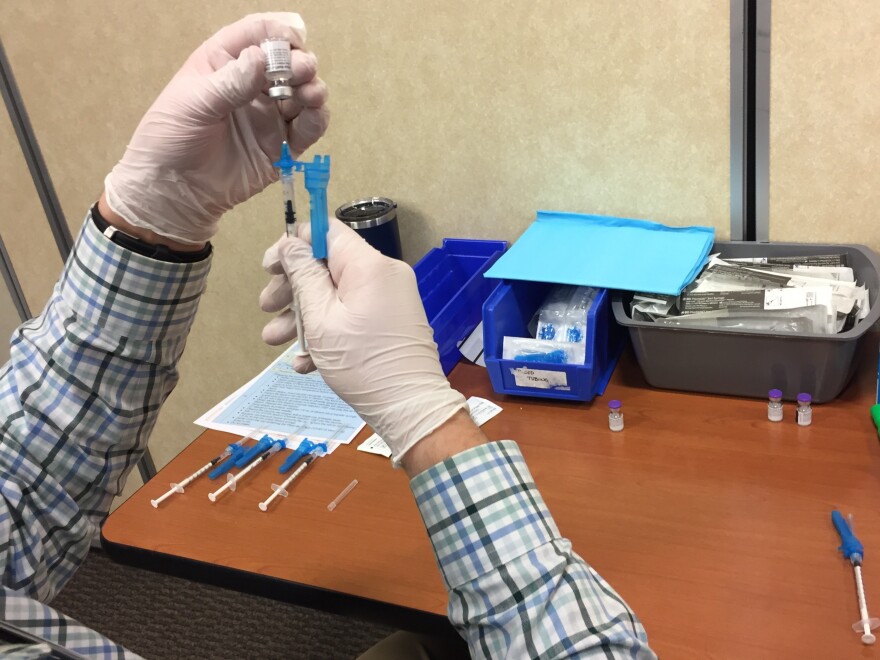 A St. Vincent Healthcare worker loads up a syringe with the vaccine Dec. 16, 2020.