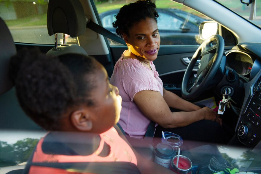 Muse-Dennis talks to her daughter Loralyn Dennis, 10, as they wait for school to open. Muse-Dennis says raising two daughters as a single mom on a teacher's salary has forced her into a 65-hour workweek. (Swikar Patel for NPR)