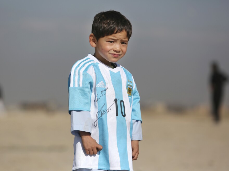 Five-year-old Murtaza Ahmadi, an avid Lionel Messi fan from Afghanistan, poses in a signed jersey from the Argentinian soccer great on Feb. 26. The boy's father says the media coverage led to threats toward the family.