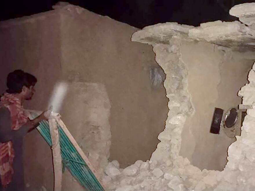 A local resident looks his damaged house following a severe earthquake hit the area, in Harnai, about 100 kilometers (60 miles) from Quetta, Pakistan, Thursday, Pakistan. A powerful earthquake shook parts of southwestern Pakistan early Thursday. (AP Photo)