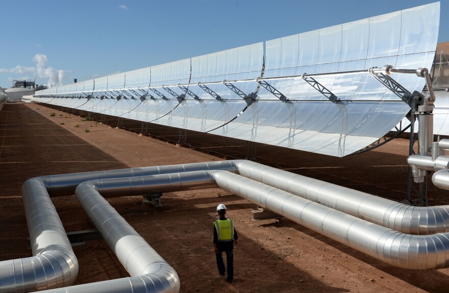 A worker walks past solar mirrors at the Noor I plant in October, while engineers were preparing for the plant's official launch.