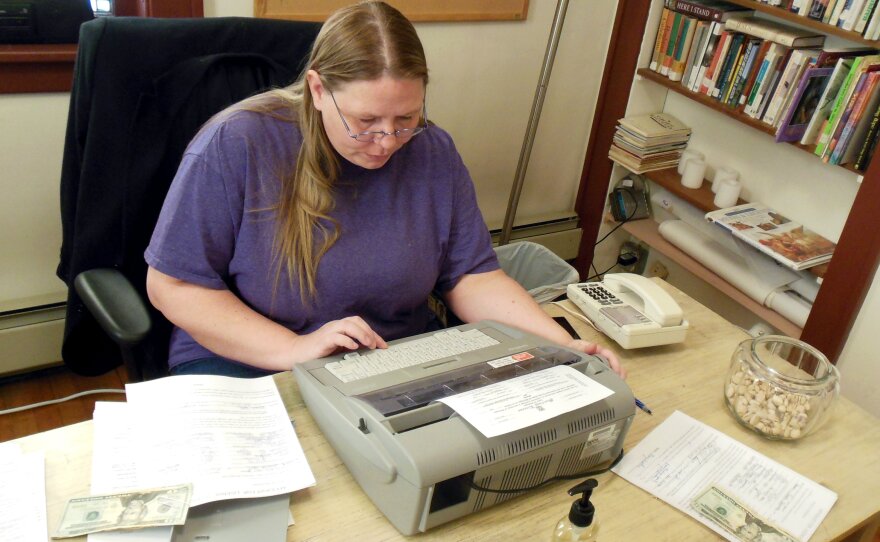 Doris Hernandez sets up a make-shift office at the church in Muskegon to type information onto the marriage licenses, which is required by state law.