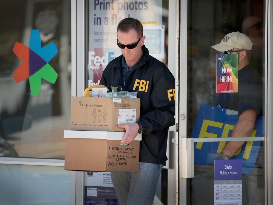 FBI agents collect evidence at a FedEx Office facility following an explosion at a nearby sorting center on March 20 in Sunset Valley, Texas. The package was reported to have been shipped from this store.