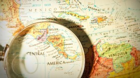Studying Geography - Photograph of Central America on retro globe underneath a magnifying glass.