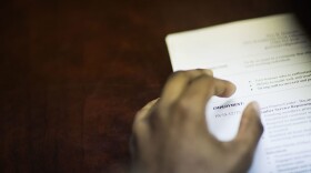 A job candidate's resume sits on a table as he interviews for a job with a restaurant during a recruiting event in Atlanta. (David Goldman/AP)
