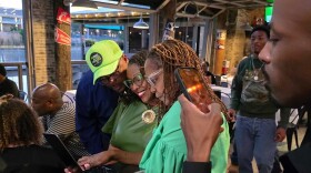 Waco District 1 Council Member Andrea Barefield looks at election updates on her computer while surrounded by supporters at a watch party on May 2, 2026.