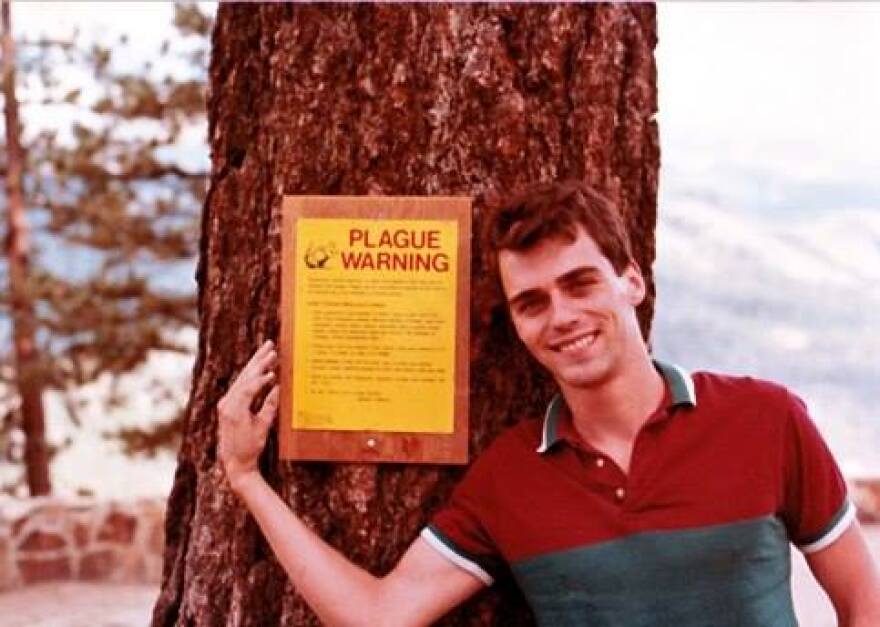 Mike Walsh, who died 31 years ago of AIDS-related brain tumor at the age of 33, is pictured besides a sign that says PLAGUE WARNING. It was taken shortly before he became ill.