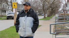 Antonio Boone walks outside on the sidewalk of the Lorain Branch of the Cleveland Public Library. 
