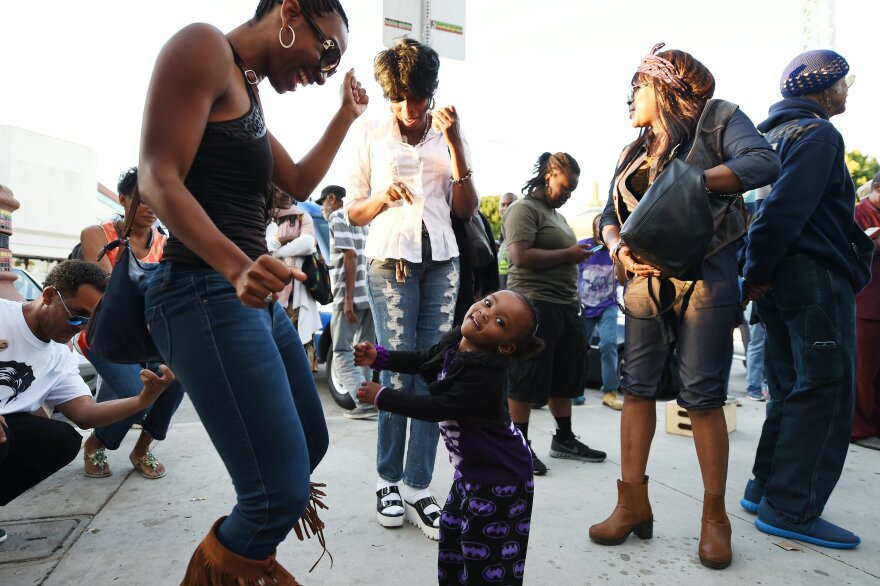 People dance to Prince's music at Leimert Park in Los Angeles where fans gathered to celebrate and remember the pop music icon's life on April 21, 2016.