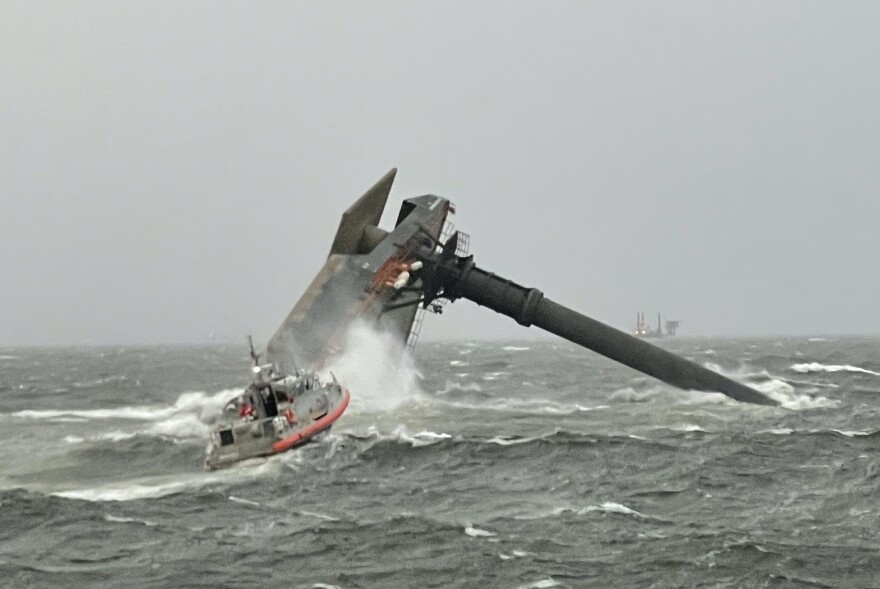 The capsized Seacor Power on the evening of the accident, with a Coast Guard response boat in the foreground.