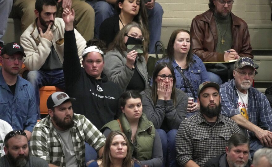 A woman raises her hand with a question during a town hall meeting at East Palestine High School in East Palestine, Ohio, Wednesday, Feb. 15, 2023. The meeting was held to answer questions about the ongoing cleanup from the Feb. 3, derailment of a Norfolk Southern freight train carrying hazardous materials.