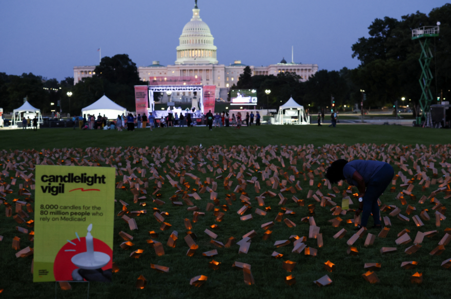 A demonstrator stands among battery powered candles in paper bags during a vigil in protest against potential cuts to Medicaid in Washington, D.C. on July 23, 2025.