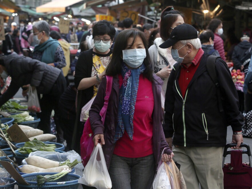 People wear face masks to help curb the spread of the coronavirus as they shop at a market in Taipei in April.