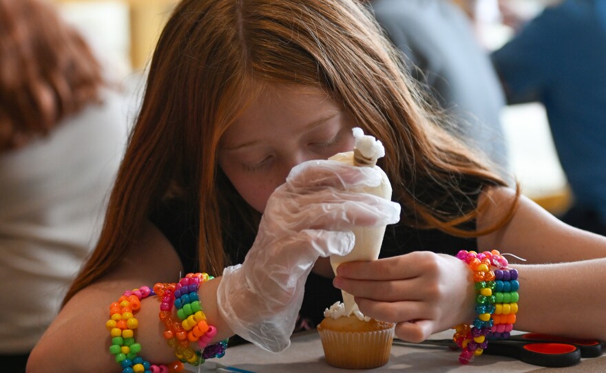 Gabrielle Beauvais, a sixth grade student, uses icing to make her cupcake look like it is topped with popcorn.