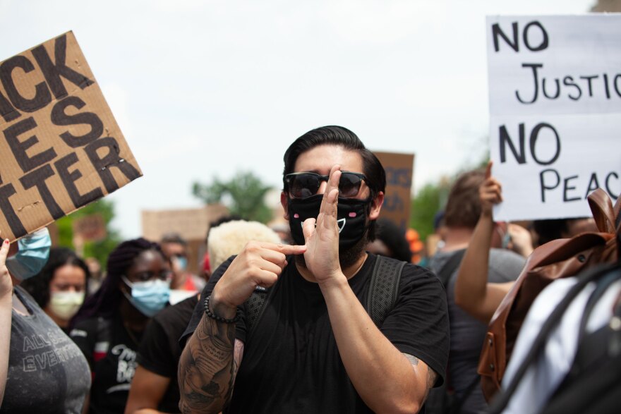 A sign language interpreter translates the protest chants following a demonstration at the Dirksen Senate Office Building on Saturday.